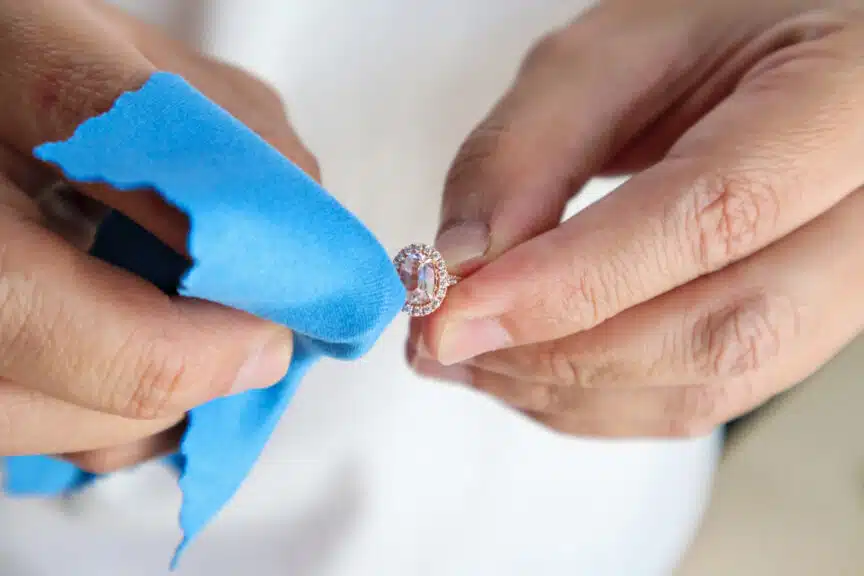 Jeweller hand polishing and cleaning jewelry diamond ring with micro fiber fabric