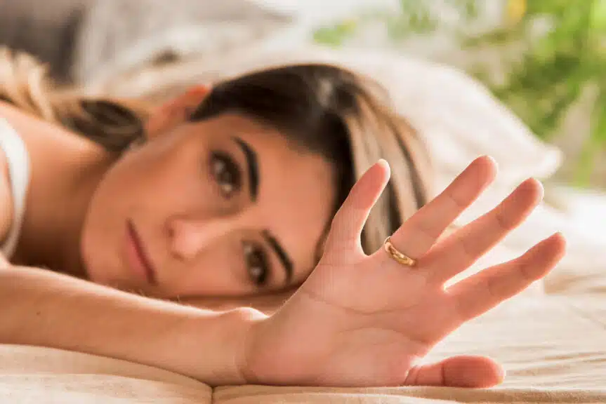 Close-up woman sadly looking at wedding ring