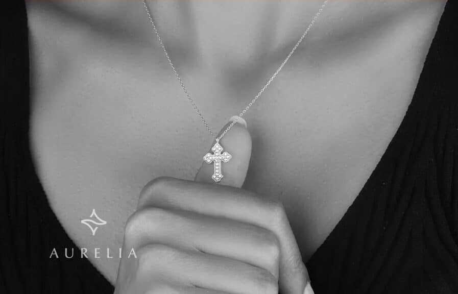 moissanite cross pendant on. MODEL'S NECK