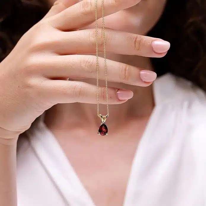 Elegant pear-shaped garnet solitaire pendant in silver, gold, or platinum. Perfect January birthstone gift for birthdays, anniversaries, or weddings.