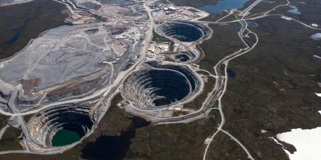 Aerial view of diamond mines in Canada, showcasing large open-pit excavations and surrounding infrastructure, illustrating At What Depth is Diamond Found in Canadian mining operations.