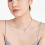 Woman wearing a floating diamond tennis necklace, showcasing 5.00 CTW lab-grown stones in 14K yellow gold for daily elegance