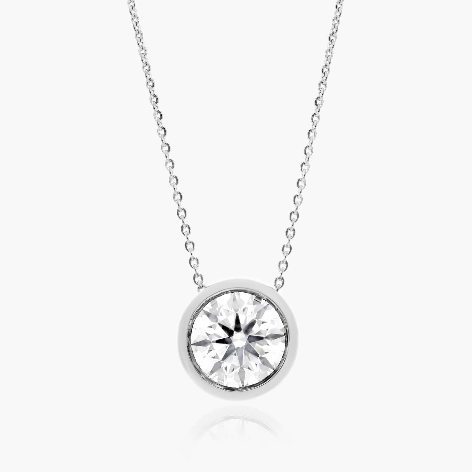 A 0.50 CTW diamond appears to float in a secure 14K white gold bezel setting. Adjustable 16-18" chain.