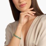 A breathtaking masterpiece featuring 19 vibrant green emeralds and over two carats of brilliant baguette diamonds set in polished 18k white gold.