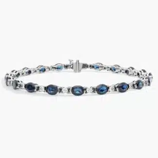 A captivating tennis-style bracelet featuring twenty vibrant blue oval sapphires elegantly alternating with brilliant round diamonds in a sleek 18k white gold setting.