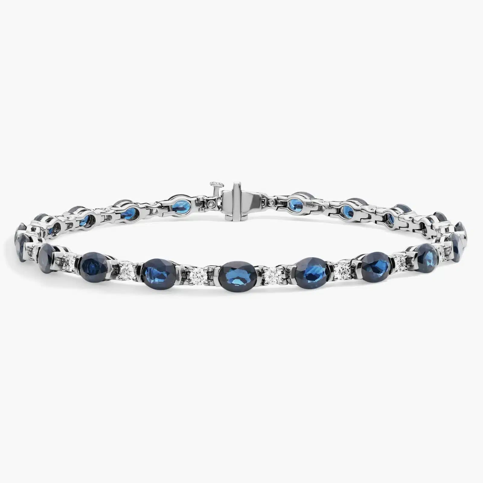 A captivating tennis-style bracelet featuring twenty vibrant blue oval sapphires elegantly alternating with brilliant round diamonds in a sleek 18k white gold setting.