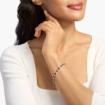 A captivating tennis-style bracelet featuring twenty vibrant blue oval sapphires elegantly alternating with brilliant round diamonds in a sleek 18k white gold setting.