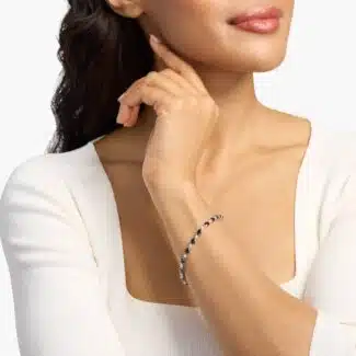 A captivating tennis-style bracelet featuring twenty vibrant blue oval sapphires elegantly alternating with brilliant round diamonds in a sleek 18k white gold setting.
