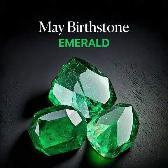 Three rough, unpolished Emerald gemstones, displaying deep green color and natural facets, with text 'May Birthstone EMERALD' overlayed, clearly identifying the May birthstone.