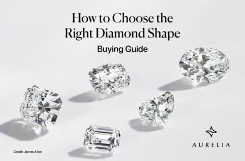 A featured image for an expert buying guide titled "How to Choose the Right Diamond Shape." The image displays five different, high-quality loose diamonds artfully scattered as if they are floating against a clean, bright, neutral background. The featured diamond shapes include some of the most popular and distinct styles: a large Oval cut, a Cushion cut, a Heart shape, a sophisticated Emerald cut, and what appears to be a brilliant Radiant cut. This professional, high-end photograph is designed to instantly showcase the beautiful variety of shapes available, drawing the reader into the comprehensive buying guide. The Aurelia brand logo is subtly placed in the corner.
