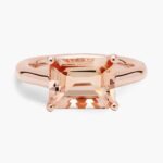A professional studio image of an **east west morganite ring** on a white background, highlighting the sleek lines of the emerald cut and the elegant 14K rose gold prong setting.