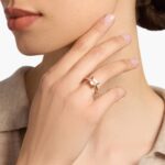 A woman's hand wearing an **east west Morganite Engagement Ring**, showcasing the unique horizontal setting of the emerald-cut gemstone in 14K rose gold.