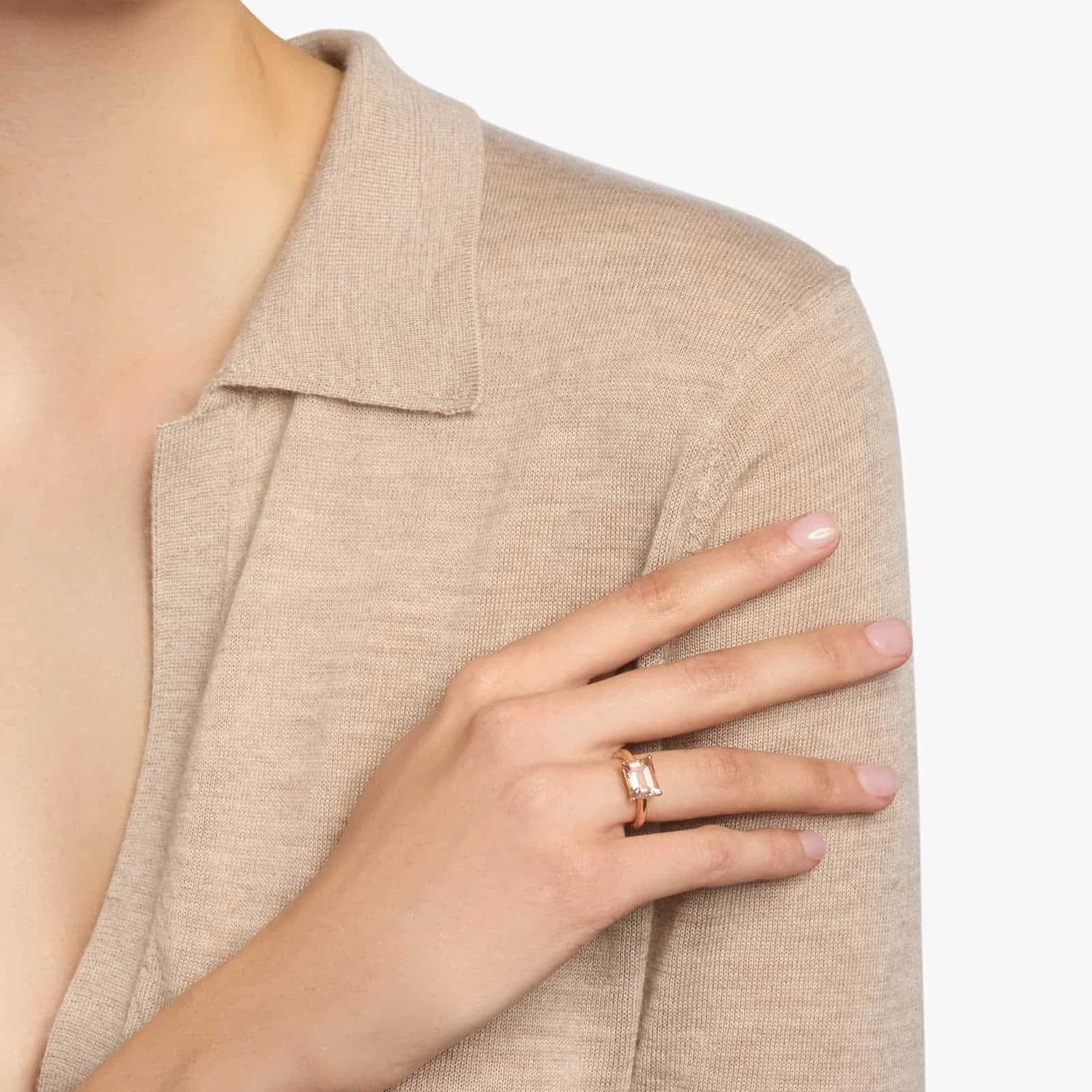 A woman's hand wearing an **east west Morganite Engagement Ring**, showcasing the unique horizontal setting of the emerald-cut gemstone in 14K rose gold.