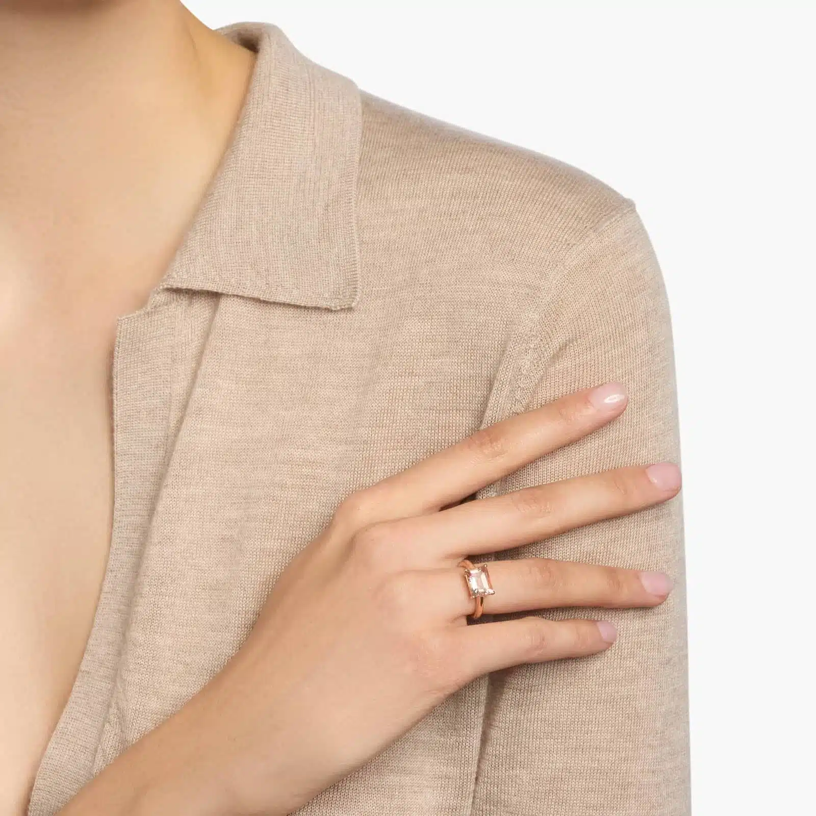 A woman's hand wearing an **east west Morganite Engagement Ring**, showcasing the unique horizontal setting of the emerald-cut gemstone in 14K rose gold.