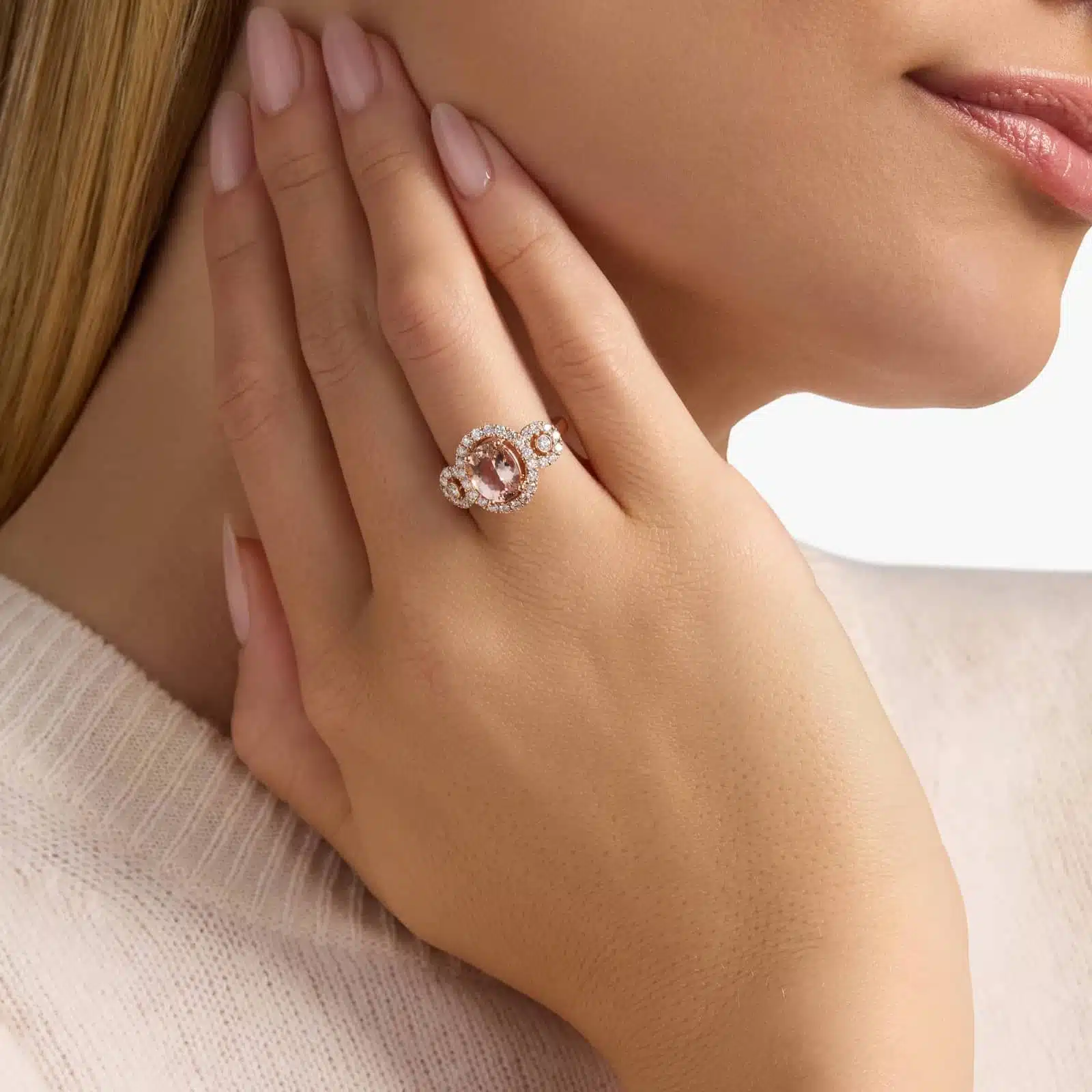 Oval Morganite Ring with Diamonds in 14k Rose Gold 2 A woman's hand wearing an **Oval Morganite Engagement Ring**, showcasing the brilliant oval morganite and the sparkling pavé diamond band in 14K rose gold.