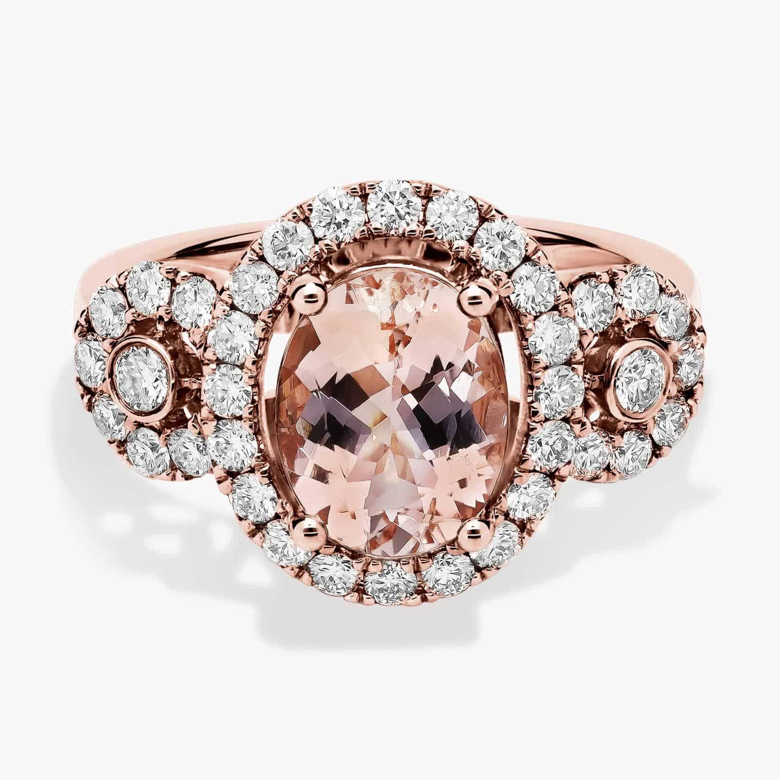 A close-up studio shot of an **oval morganite and diamond ring** on a white background, highlighting the central stone, the bezel-set diamonds, and the intricate pavé detail on the band.
