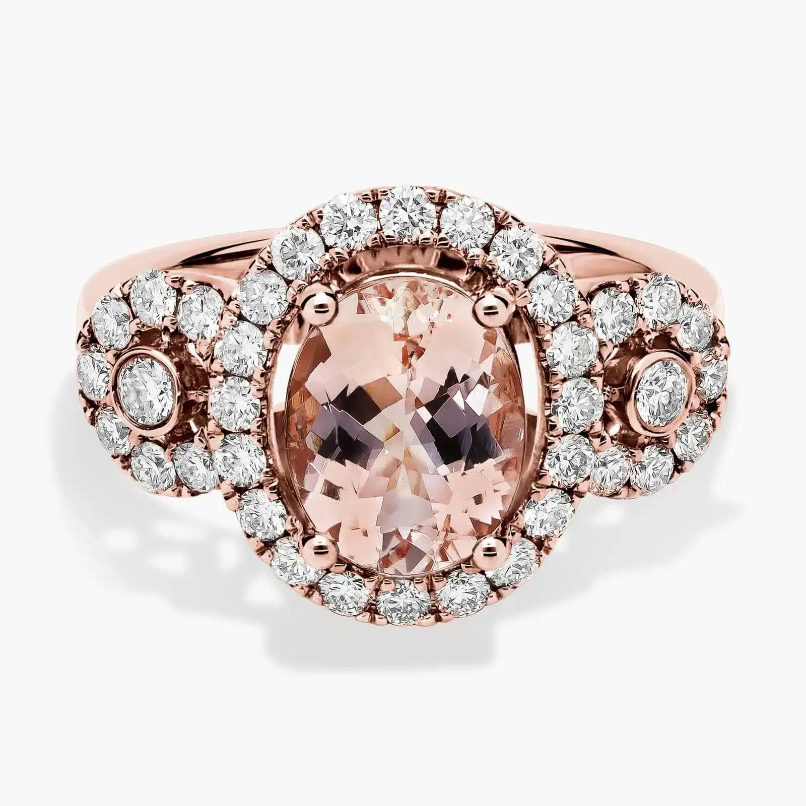 Oval Morganite Ring with Diamonds in 14k Rose Gold A close-up studio shot of an **oval morganite and diamond ring** on a white background, highlighting the central stone, the bezel-set diamonds, and the intricate pavé detail on the band.