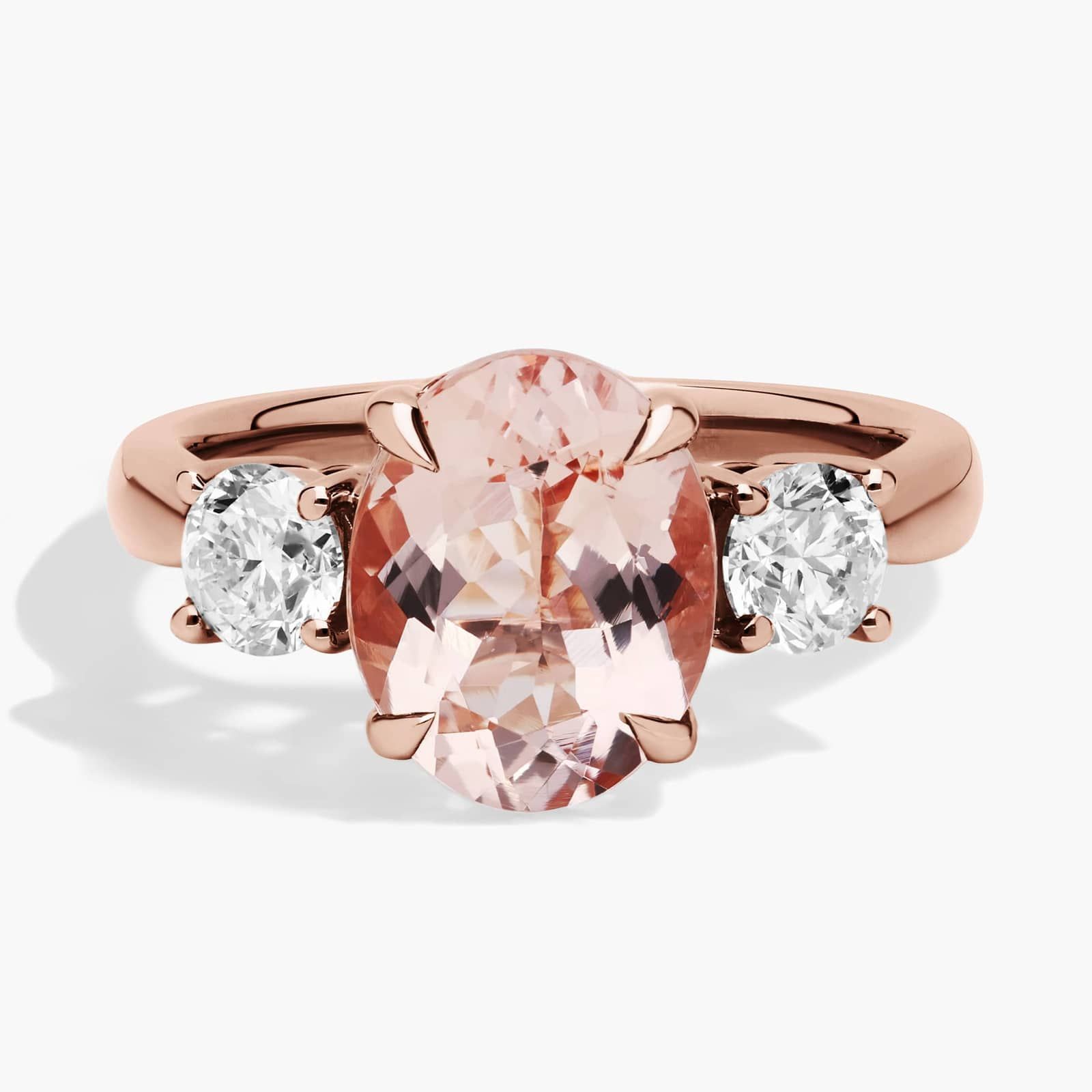 A close-up of a beautiful **Morganite Engagement Ring** on a white background, highlighting the distinct prongs, two round diamond sidestones, and the unique pink color of the 14K rose gold.