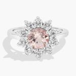 A close-up studio shot of a **round morganite and diamond halo ring** on a white background, highlighting the classic shape of the center stone and the sparkling pavé-set diamonds.