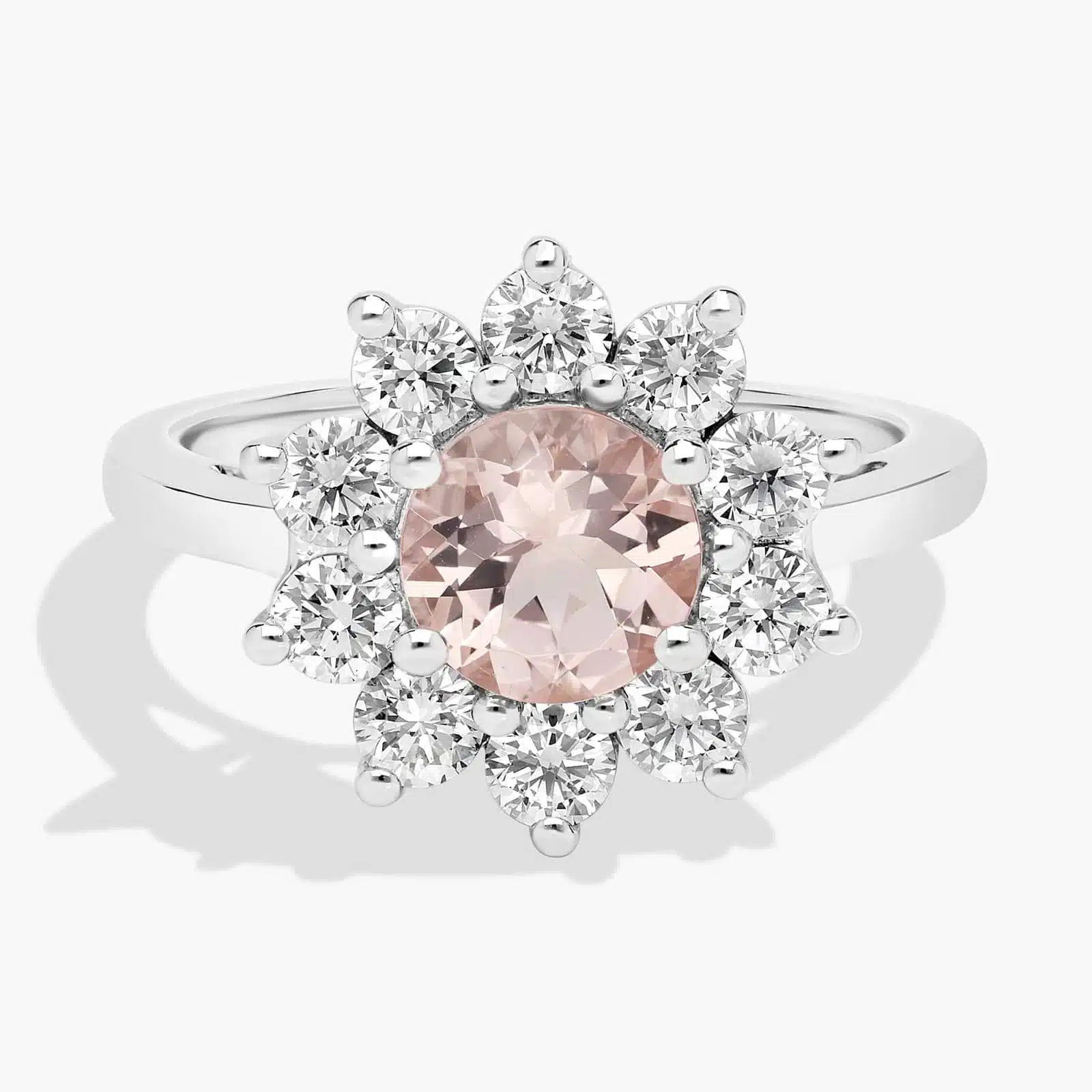 A close-up studio shot of a **round morganite and diamond halo ring** on a white background, highlighting the classic shape of the center stone and the sparkling pavé-set diamonds.