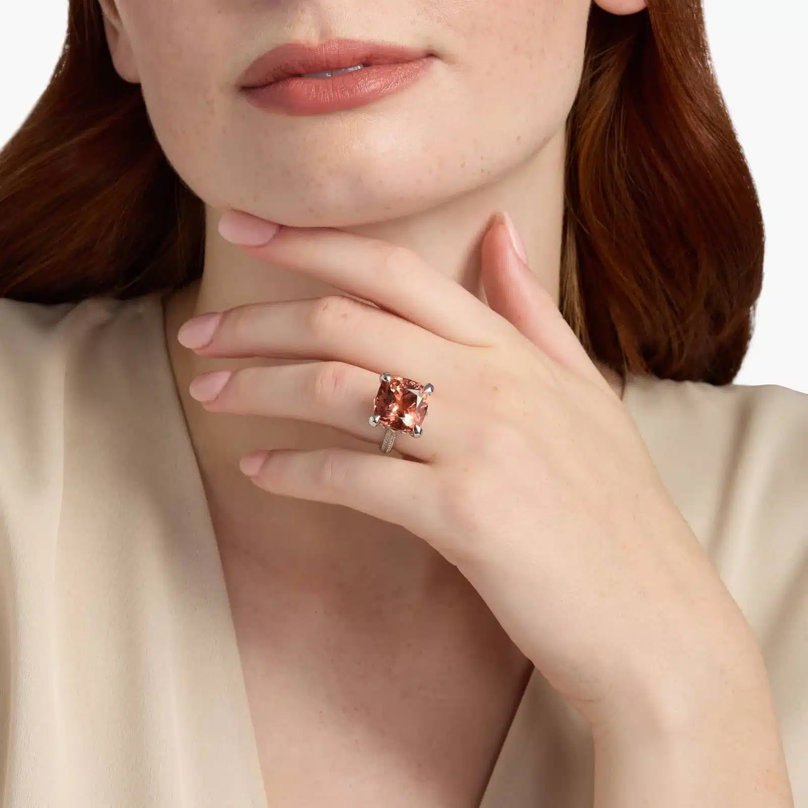 A woman's hand wearing a large **Square Fire Morganite Engagement Ring**, showcasing the impressive 14x14mm cushion-cut morganite and the sparkling pavé diamond band in 18K white gold.