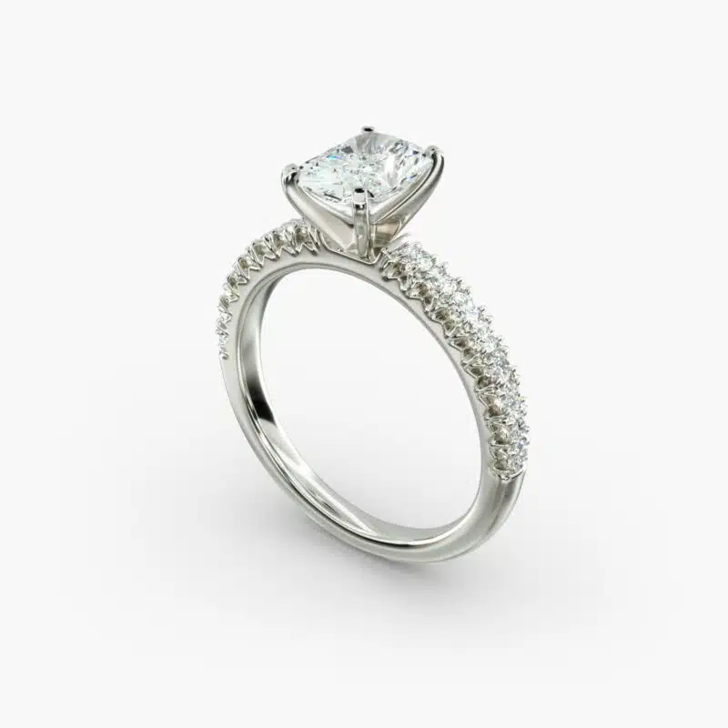 A close-up studio shot of a 3ct radiant cut diamond ring, highlighting the G-VVS2 clarity of the center stone and the intricate pavé setting.