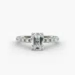 A close-up studio shot of a **7 carat diamond ring**, highlighting the stunning clarity of the emerald cut diamond and the delicate detail of the French pavé side stones.