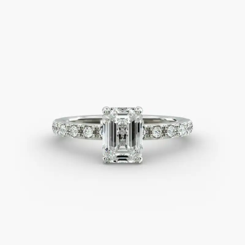 A close-up studio shot of a **7 carat diamond ring**, highlighting the stunning clarity of the emerald cut diamond and the delicate detail of the French pavé side stones.