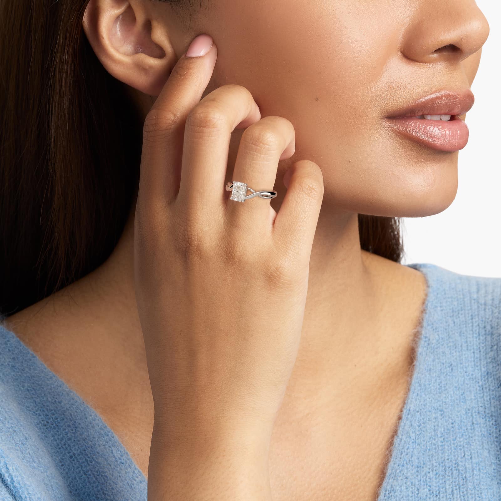 A woman's hand wearing a large 3.5 carat radiant cut diamond ring with a D-VS1 center stone in a platinum twist solitaire setting.
