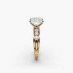 A close-up side view of a 2.5 carat radiant cut diamond ring in 14k yellow gold, highlighting the channel-set diamonds.