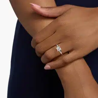 A hand wearing a classic 2 carat princess cut lab-grown diamond engagement ring, showing off the E-VVS1 center stone.