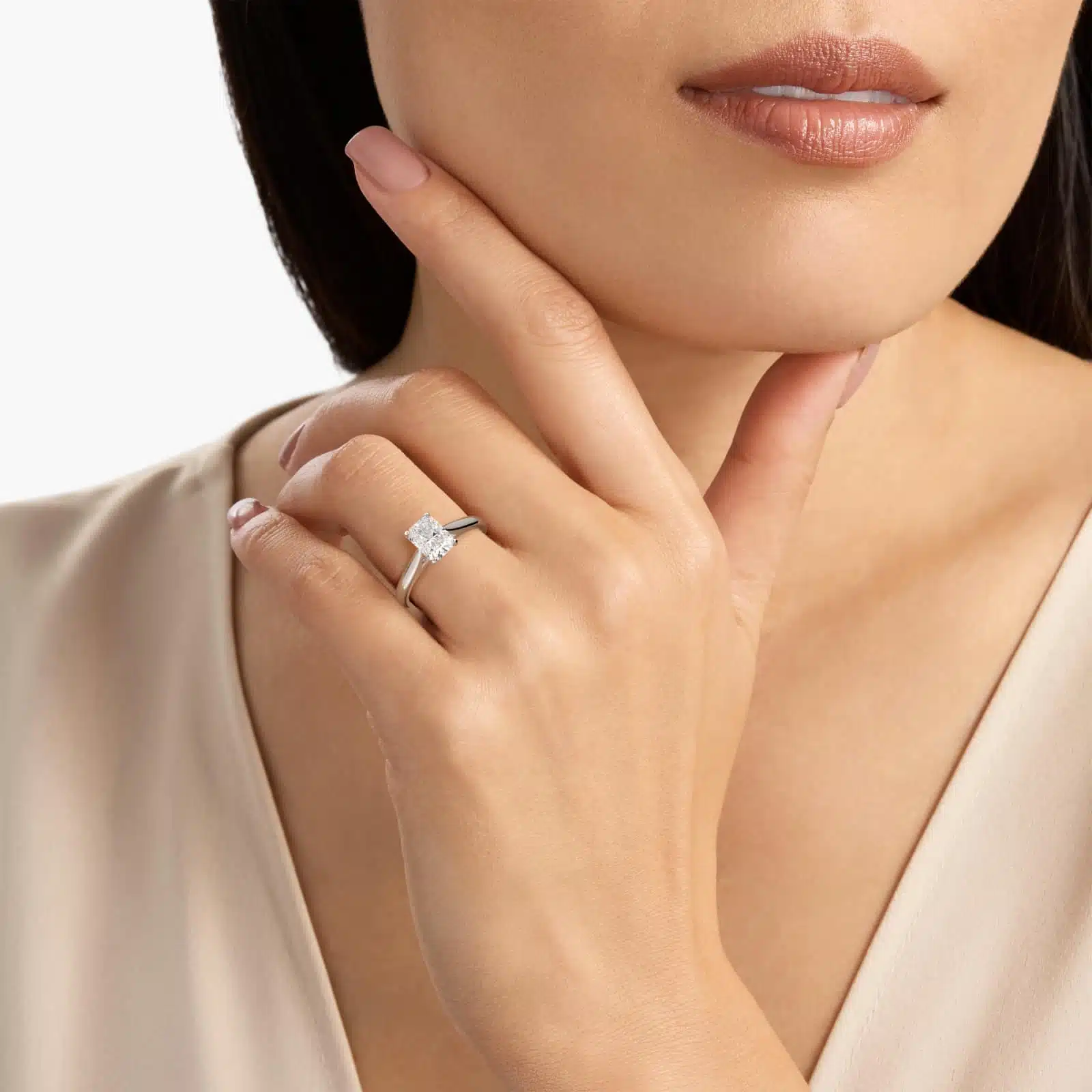 A woman's hand wearing a massive 4 carat radiant cut diamond ring with a D-VVS1 lab-grown center stone in a white gold Tapered Cathedral setting.