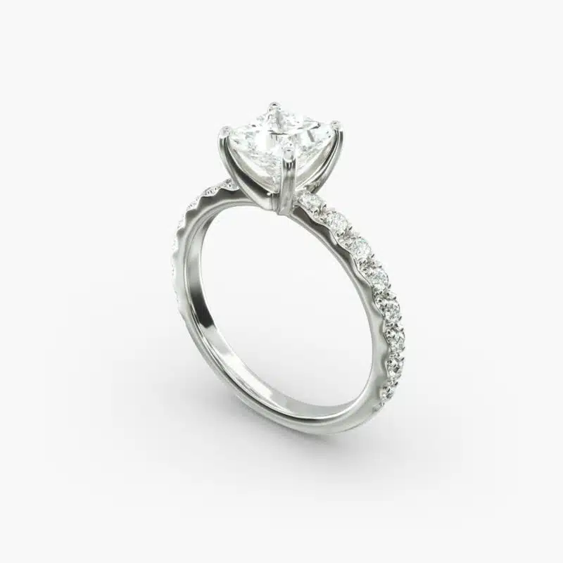 A close-up studio shot of a **7 carat diamond ring**, highlighting the sharp corners of the Princess cut diamond and the delicate detail of the French pavé side stones.