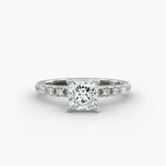 A close-up studio shot of a **7 carat diamond ring**, highlighting the sharp corners of the Princess cut diamond and the delicate detail of the French pavé side stones.