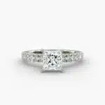 A close-up side view of a 2 carat princess cut diamond engagement ring, highlighting the F-VVS1 clarity of the center stone and the detailed French pavé setting.