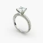 A close-up side view of a 2 carat princess cut diamond engagement ring, highlighting the F-VVS1 clarity of the center stone and the detailed French pavé setting.