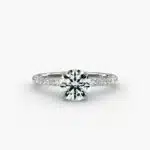 A studio shot of a **Hearts and Arrows Diamond Engagement Ring**, highlighting the precision cut of the round diamond and the delicate pavé side stones on the 14K white gold band.