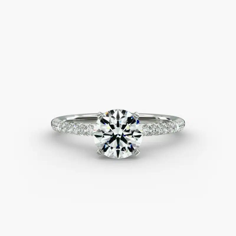 A studio shot of a **Hearts and Arrows Diamond Engagement Ring**, highlighting the precision cut of the round diamond and the delicate pavé side stones on the 14K white gold band.