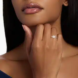 A woman's hand wearing an elegant 2 carat princess cut diamond engagement ring, showcasing the F-VS2 princess-cut center stone and tapered baguette side diamonds.