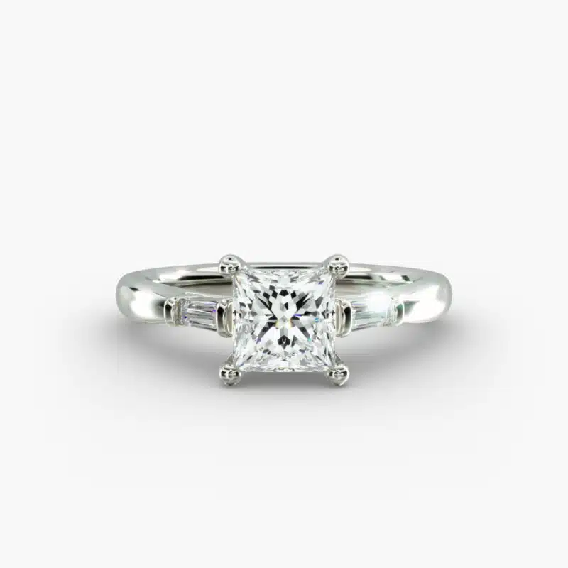 A close-up studio shot of a 2 carat princess cut diamond engagement ring, highlighting the straight lines of the princess and baguette diamonds set in 14K white gold.