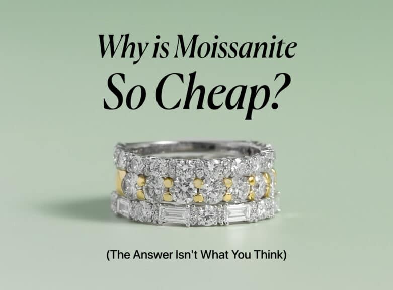 An elegant image showing three stacked rings with glittering moissanite gems on a pale green background. The top ring is a simple band of round stones, the middle ring alternates between round stones and yellow-gold sections, and the bottom ring features baguette-cut stones. The title "Why is Moissanite So Cheap?" is centered above the rings with the subtitle "(The Answer Isn't What You Think)" below them.