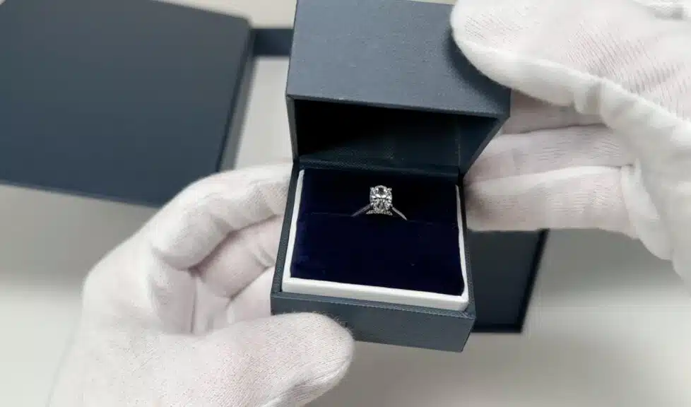The first look at the Blue Nile oval lab-grown diamond engagement ring, sparkling inside the open ring box on a velvet cushion.