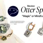 A graphic title card for an article. The text "Otter Spirit Review" is at the top left, with a dark circular logo featuring the profile of an otter's head to the right. Below, the text "Magic or Mindfulness?" is in a muted pink font. The bottom left has "?/5", and the bottom right has "The Jeweler's Honest Verdict."