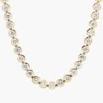 A spectacular lab created diamond tennis necklace featuring 20 CTW of F-G/VS2-SI1 round lab-grown diamonds in an illusion setting, handcrafted in radiant 14K Yellow Gold.