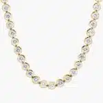 A spectacular lab created diamond tennis necklace featuring 20 CTW of F-G/VS2-SI1 round lab-grown diamonds in an illusion setting, handcrafted in radiant 14K Yellow Gold.