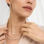 A woman wearing a spectacular 14K Yellow Gold lab created diamond tennis necklace with 80 round lab-grown diamonds totaling 20 CTW in an illusion setting.