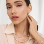 A woman wearing a spectacular 14K Yellow Gold lab created diamond tennis necklace with 80 round lab-grown diamonds totaling 20 CTW in an illusion setting.