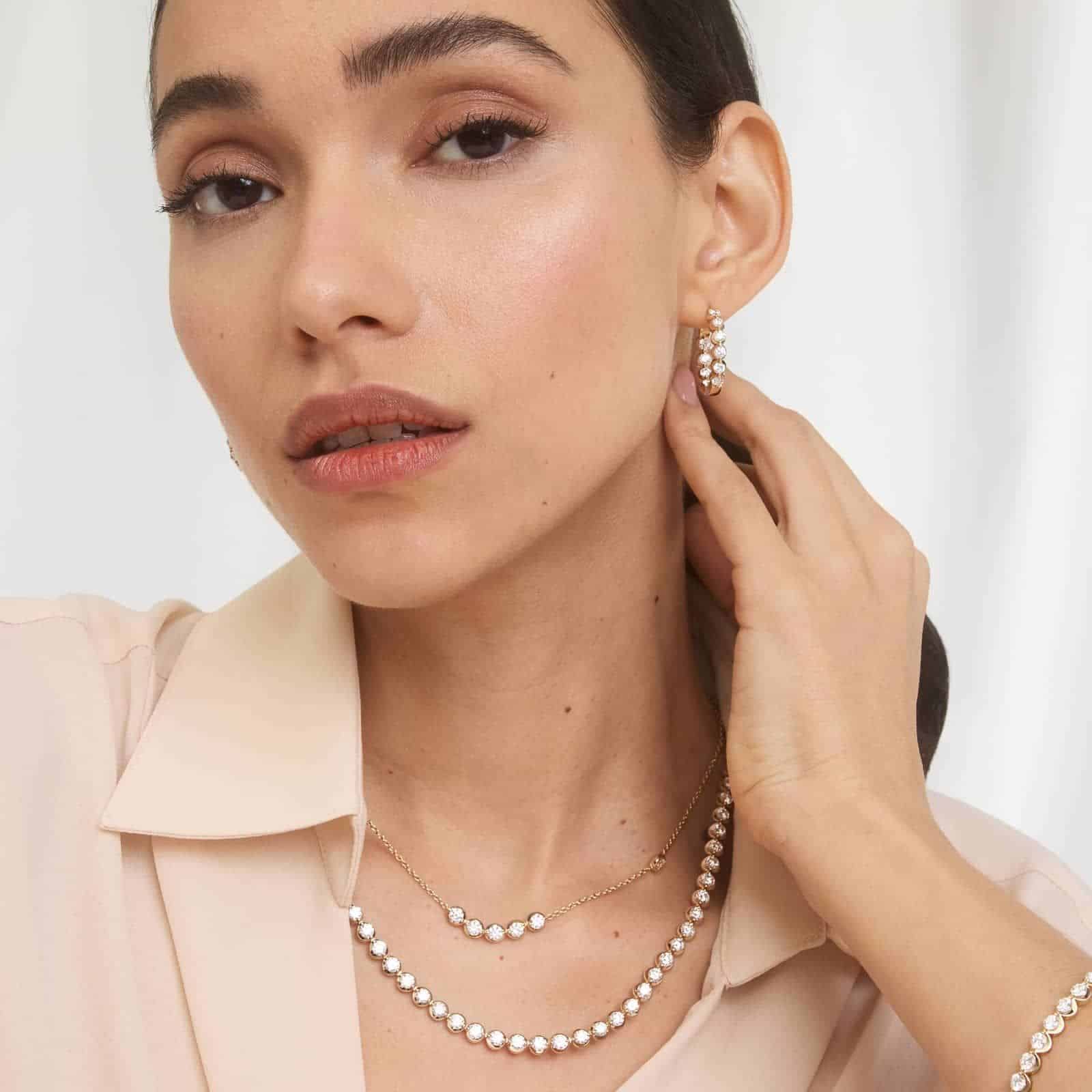 20 CTW Illusion Lab Created Diamond Tennis Necklace 3 A woman wearing a spectacular 14K Yellow Gold lab created diamond tennis necklace with 80 round lab-grown diamonds totaling 20 CTW in an illusion setting.