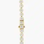A spectacular lab created diamond tennis necklace featuring 20 CTW of F-G/VS2-SI1 round lab-grown diamonds in an illusion setting, handcrafted in radiant 14K Yellow Gold.