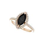 A close-up view of a marquise cut diamond ring, highlighting the 10x5 MM black onyx center stone and prong setting.
